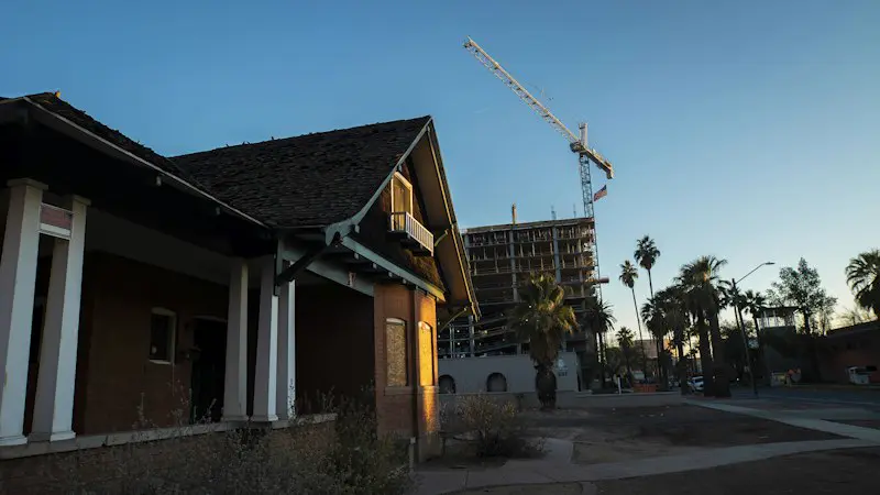 A house under construction near palm trees in the desert sun.